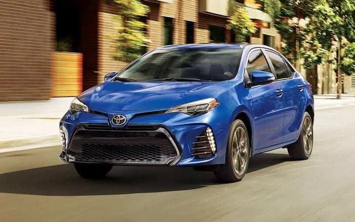 Blue Toyota sedan driving along a city street